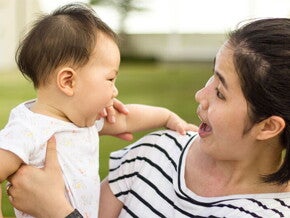 Asian woman looking at her baby trying to talk Asian woman looking at her baby trying to talk