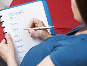 Cropped photo of a pregnant woman writing a list of unique girl names