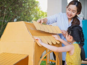 Mom and daughter making a cardboard house. 
