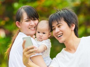 Asian couple takes a selfie with their baby.