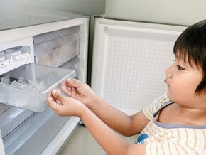 Young Asian boy looking for ice to eat, experiencing pica, one of the 5 weird signs of iron deficiency in kids.