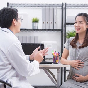 A pregnant Asian woman talking to her doctor, learning about the 4 stages of labor A pregnant Asian woman talking to her doctor, learning about the 4 stages of labor