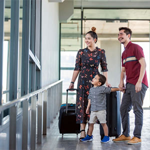 A young Asian mom, dad, and little boy at the airport with suitcases, getting ready to create memories through family travel. A young Asian mom, dad, and little boy at the airport with suitcases, getting ready to create memories through family travel.