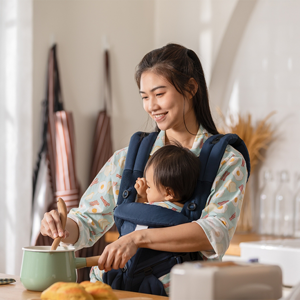 A young Asian woman carrying her baby and cooking food to ensure she gets vitamins for breastfeeding moms.