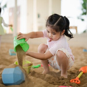 Asian girl playing with sand toys.