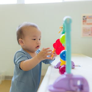 Asian baby plays appropriate toy for a 1-year-old at home.
