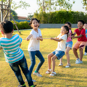 Asian children of mixed genders play tug-of-war outdoors Asian children of mixed genders play tug-of-war outdoors