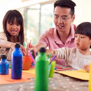 Asian dad with his kids doing arts and crafts as gift ideas for mothers