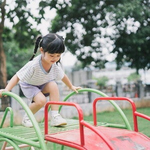 Asian girl, who doesn't show any signs of low calcium, climbs up the slide at a playground. Asian girl, who doesn't show any signs of low calcium, climbs up the slide at a playground.
