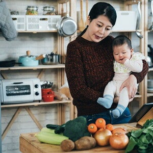 Asian mom and son looking at table of vegetables Asian mom and son looking at table of vegetables