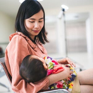 Asian mom consoling crying baby Asian mom consoling crying baby