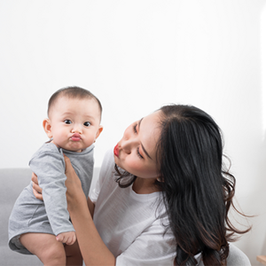Asian mom playfully imitates her 1-year-old baby's pouting lips Asian mom playfully imitates her 1-year-old baby's pouting lips