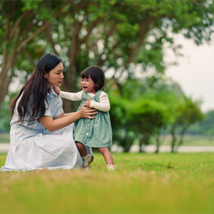 Asian mom trying to console her crying toddler