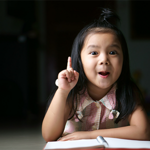 Asian preschool-age girl raises her index finger to gesture number 1.