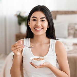 Asian woman eats a bowl of oatmeal Asian woman eats a bowl of oatmeal