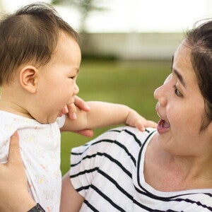 Asian woman looking at her baby trying to talk
