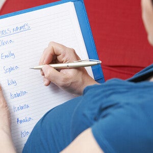 Cropped photo of a pregnant woman writing a list of unique girl names