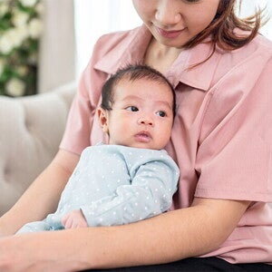 Mom holding newborn baby on couch Mom holding newborn baby on couch