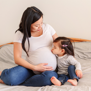 Pregnant Asian gets a kiss on her baby bump from her toddler daughter Pregnant Asian gets a kiss on her baby bump from her toddler daughter