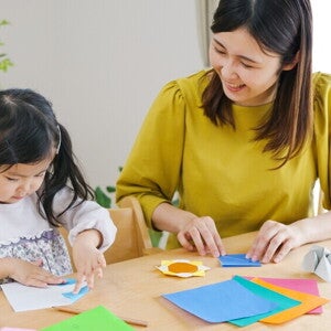 Asian mom and child crafting with construction paper Asian mom and child crafting with construction paper