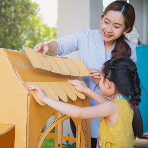 Mom and daughter making a cardboard house. Mom and daughter making a cardboard house.