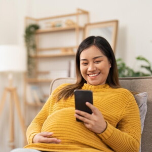 Pregnant Asian woman using her phone