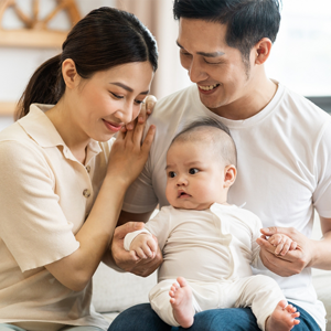 Smiling mother and father holding newborn son at home, considering birth control methods for family planning Smiling mother and father holding newborn son at home, considering birth control methods for family planning