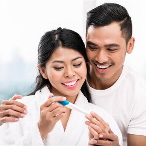 Young Asian woman is 1 month pregnant and surprises her husband with a positive pregnancy test. Young Asian woman is 1 month pregnant and surprises her husband with a positive pregnancy test.