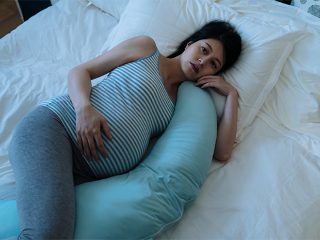 A pregnant Asian woman lying in bed awake due to insomnia during pregnancy A pregnant Asian woman lying in bed awake due to insomnia during pregnancy