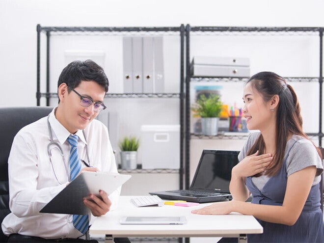 A young Asian woman talking to her doctor about her concerns regarding her high-risk pregnancy A young Asian woman talking to her doctor about her concerns regarding her high-risk pregnancy