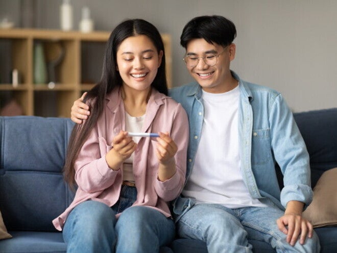 Happy Asian couple discovers they’re expecting and want to start a healthy pregnancy journey. 