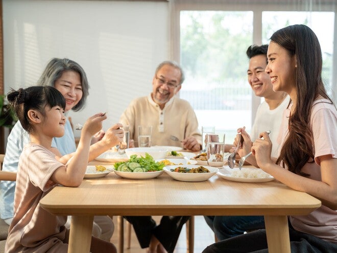 An Asian extended family eating together in the dining room.