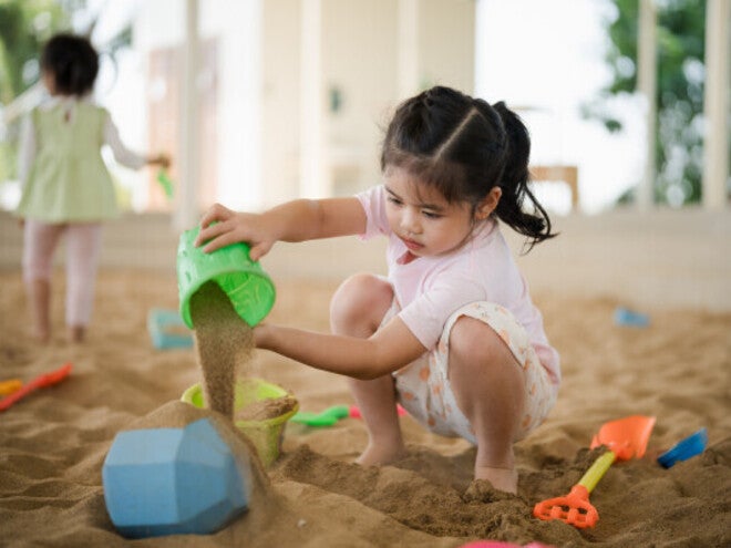 Asian girl playing with sand toys.