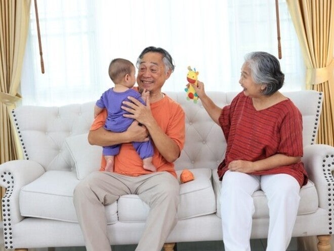 Happy Asian lolo and lola taking care of their toddler grandchild and using grandparenting tips to be better at co-parenting.