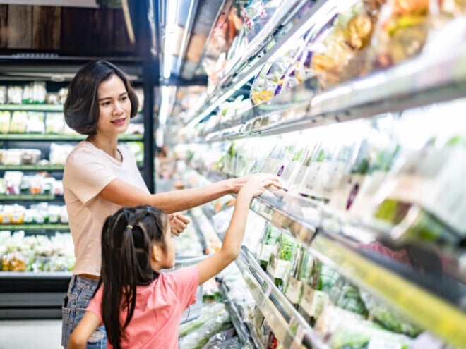 Filipino mother and daughter grocery shopping, buying vegetables for nutritious food.