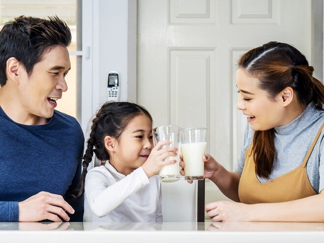 asian-parents-little-girl-with-glasses-of-fresh-milk-and-growing-up-milk