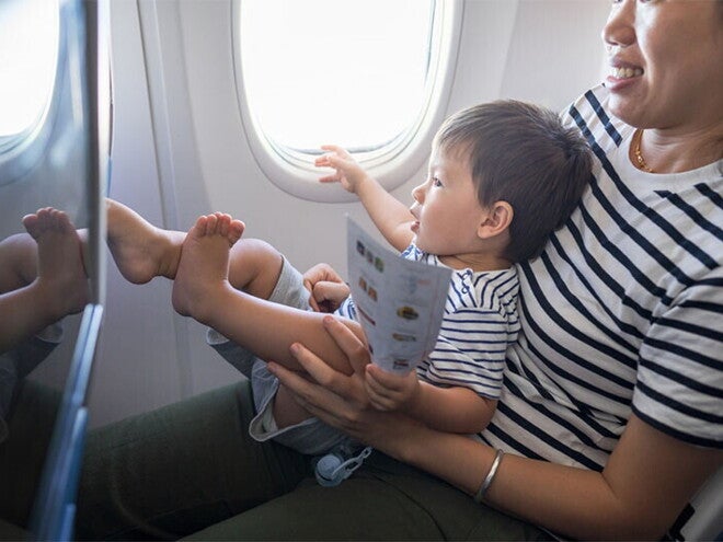 Asian baby sitting on mother’s lap on plane Asian baby sitting on mother’s lap on plane