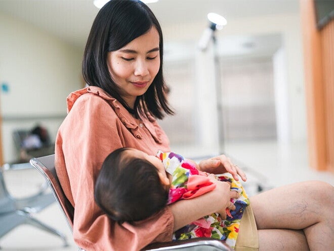 Asian mom consoling crying baby Asian mom consoling crying baby