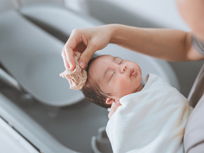 Asian mom washing newborn child in their baby bath Asian mom washing newborn child in their baby bath.