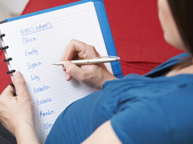 Cropped photo of a pregnant woman writing a list of unique girl names