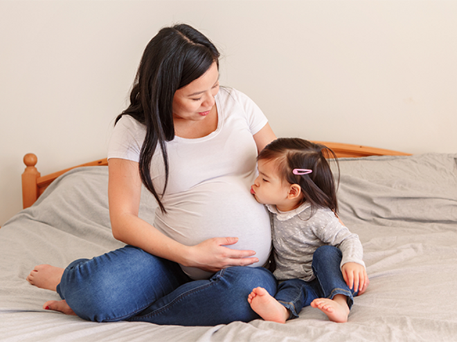 Pregnant Asian gets a kiss on her baby bump from her toddler daughter Pregnant Asian gets a kiss on her baby bump from her toddler daughter