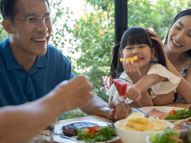 Header_Image Young Asian family enjoy a meal together.