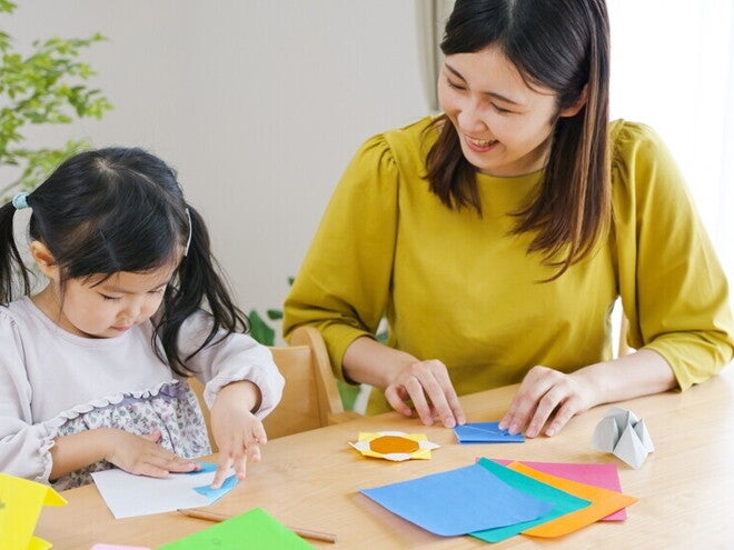 Asian mom and child crafting with construction paper