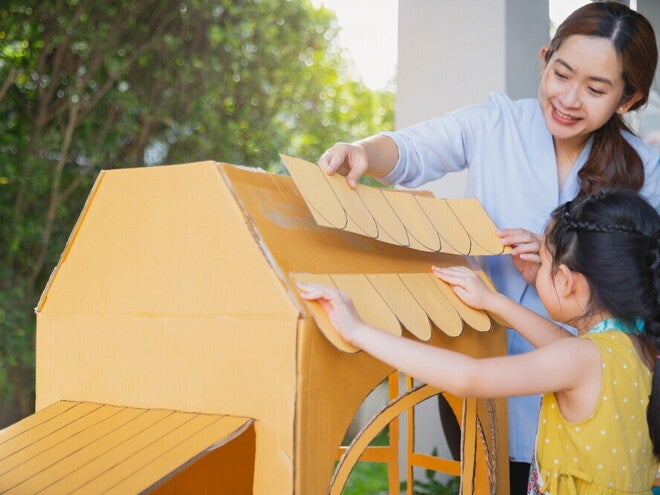 Mom and daughter making a cardboard house