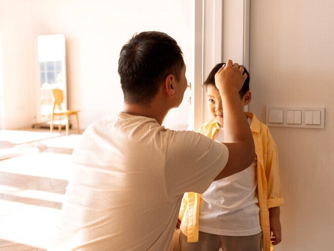 Asian dad marks his son's height on the wall to record growth milestone Asian dad marks his son's height on the wall to record growth milestone