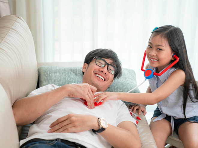 Young Asian girl listens to her father's heartbeat with a toy stethoscope, pretending to do dad’s medical checkups Young Asian girl listens to her father's heartbeat with a toy stethoscope, pretending to do dad’s medical checkups