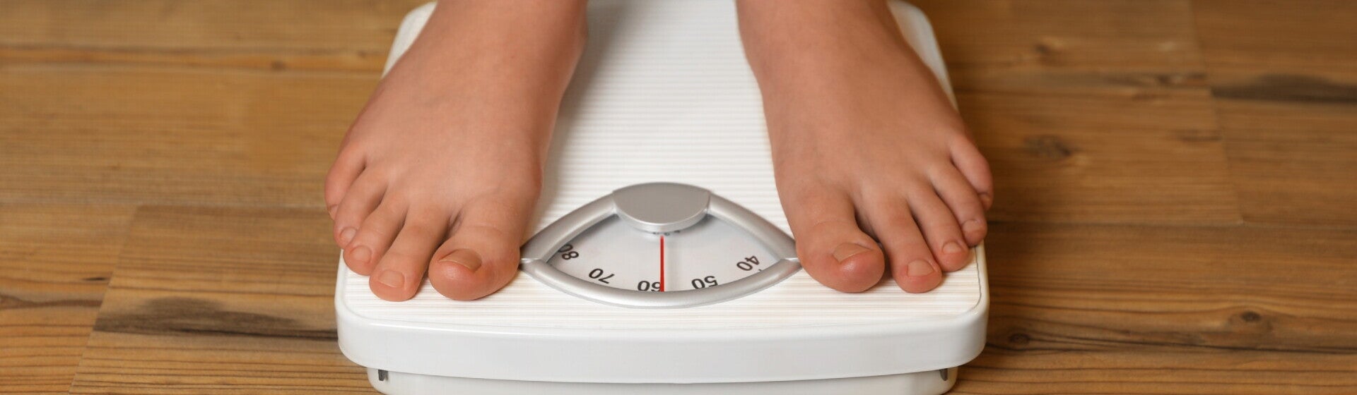 Close-up of child’s feet on weighing scale.