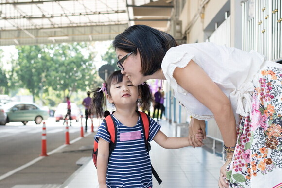 Article_Image-2 Filipino mom leans down to listen to her daughter during a school drop-off.
